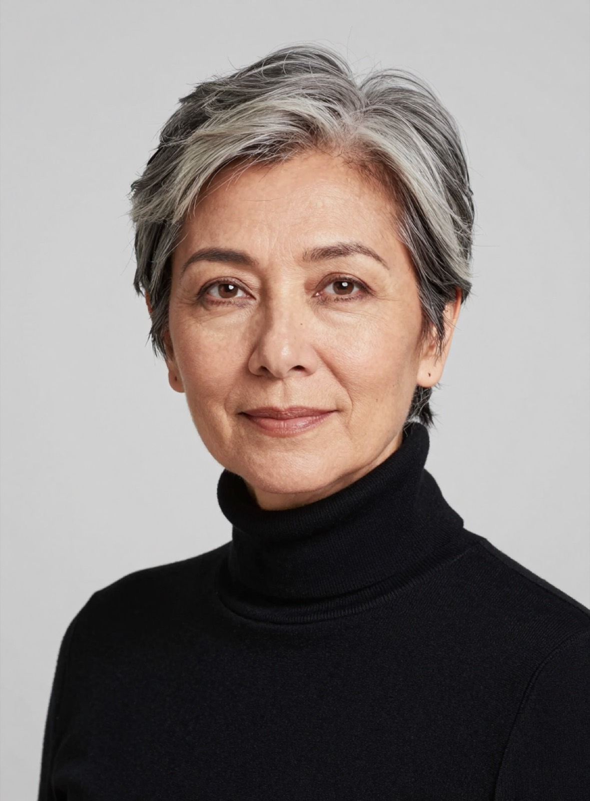 Retrato de Amparo Rioseco: mujer de pelo gris corto y cuello alto negro, sonrisa leve