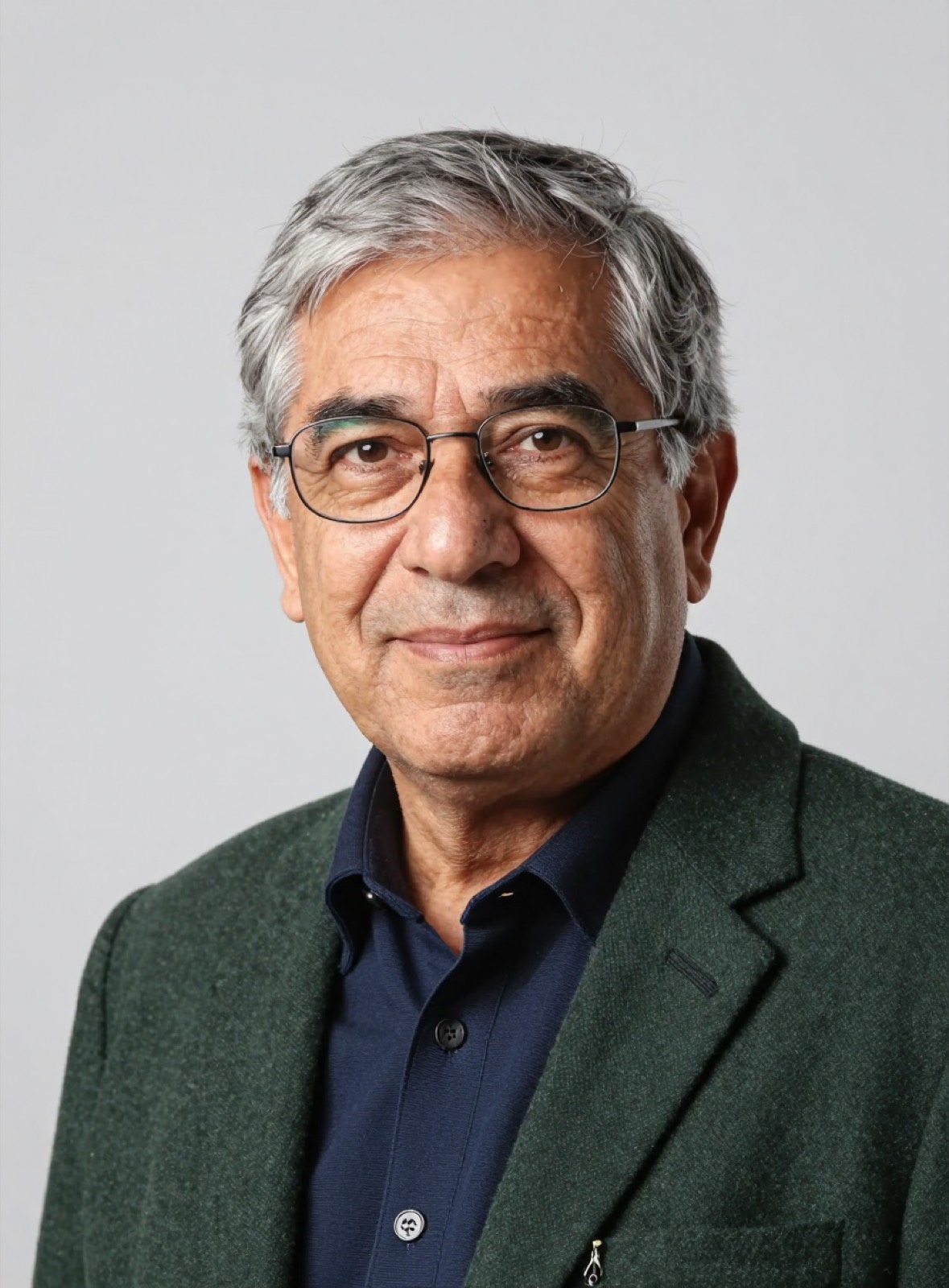 Retrato de Hernán Soto: hombre de pelo gris con lentes, chaqueta de lana verde oscuro